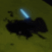 a blurry picture of a blue light coming out of a black object