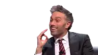 a man in a suit and tie laughing with his mouth open