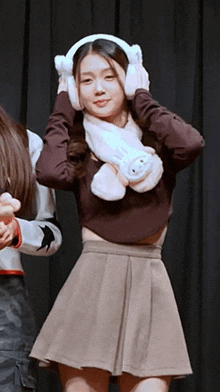 a woman wearing ear warmers and a scarf with a bunny on it