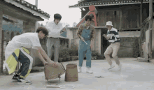 a group of young men are playing with a badminton racket and a bucket