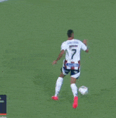 a soccer player with the number 7 on his back kicks the ball