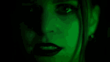a close up of a woman 's face with green lights behind her .