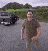 a man in a brown shirt is running in front of a car that says viggle.ai on the bottom