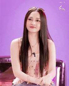 a woman with long hair wearing sunglasses and a necklace