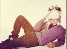 a person wearing a purple hoodie and a white hat