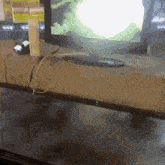 a computer monitor is sitting on a table next to a box and a cord .
