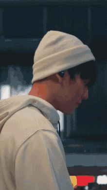 a young man wearing a white beanie and headphones