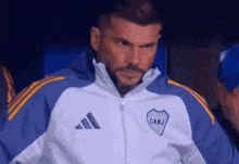 a man wearing a blue and white jacket with cabj on it