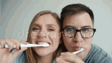 couple brushing teeth smiling