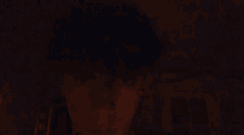 a person 's face is visible in the dark with a blurred background