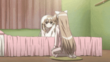 a girl looking at herself in a mirror while sitting on a bed