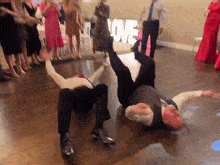 a group of people dancing in front of a sign that says love