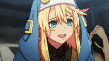 a girl with blonde hair and green eyes is wearing a blue hoodie