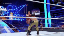 two wrestlers are wrestling in a ring with a sign that says wwe live