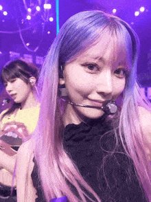 a girl with purple and pink hair is wearing a headset