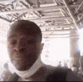 a man wearing a mask is taking a selfie in front of a crowd of people .
