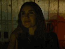 a woman is smiling in a dark room with a light in the background