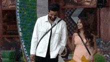 a man and a woman are standing next to each other in a room .