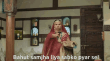 a woman in a red dress is standing in a room with the words bahut samjha lya sabko pyar se