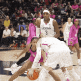 a uconn basketball player tries to block another player from getting the ball