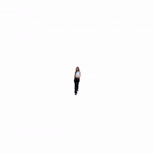 a woman in a white tank top and black pants is walking