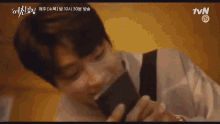 a man is laying on the floor holding a cell phone in his hand .