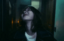 a woman in a black jacket is looking up at the sky .