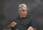 a man in a black shirt is waving his hand in the air