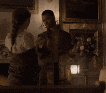 a man and a woman are holding hands in a room