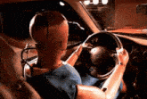 a mannequin is sitting in the driver 's seat of a car with a steering wheel