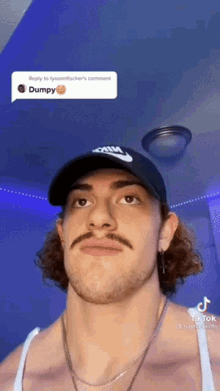a man with a mustache wearing a nike hat and a necklace