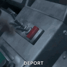 a person is pressing a red button which says deport