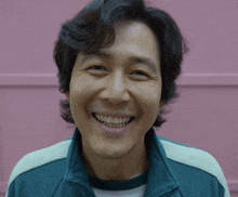 a man wearing a green jacket and white shirt smiles for the camera