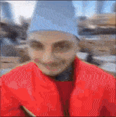 a blurry image of a person wearing a red jacket and a blue hat