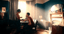 a man sits at a table with a woman standing behind him