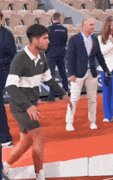 a man wearing a nike sweater is walking on a red carpet