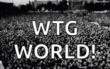 a black and white photo of a crowd with the words wtg world in white letters