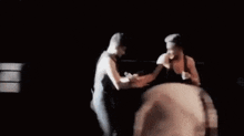 a couple of men are standing next to each other on a stage .