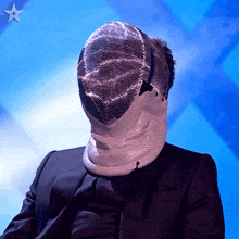 a man wearing a fencing mask with a star in the background