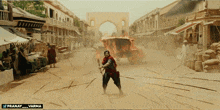 a man in a red cape is standing in front of a burning carriage with the twitter handle pranay_varma