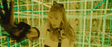 a woman in a cat costume is standing in a maze holding a cat .
