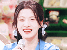 a girl with pigtails is smiling and holding a microphone with gulubby written on the bottom