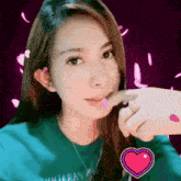 a woman in a green sweater with a heart on her chest