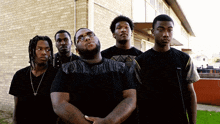 a group of young men standing in front of a building