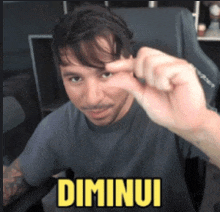 a man sitting in a chair with the word dimunui written on his face