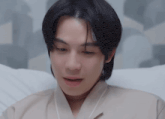 a young man laying on a bed looking at something