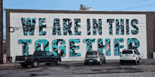 a mural on a building says we are in this together