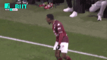 a soccer player is running on a field with the word ruit on the bottom