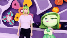 a woman with green hair is standing next to a green doll