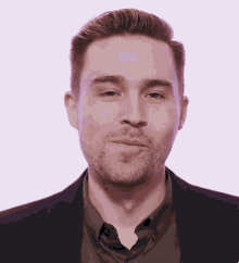 a man with a beard is wearing a purple jacket and brown shirt